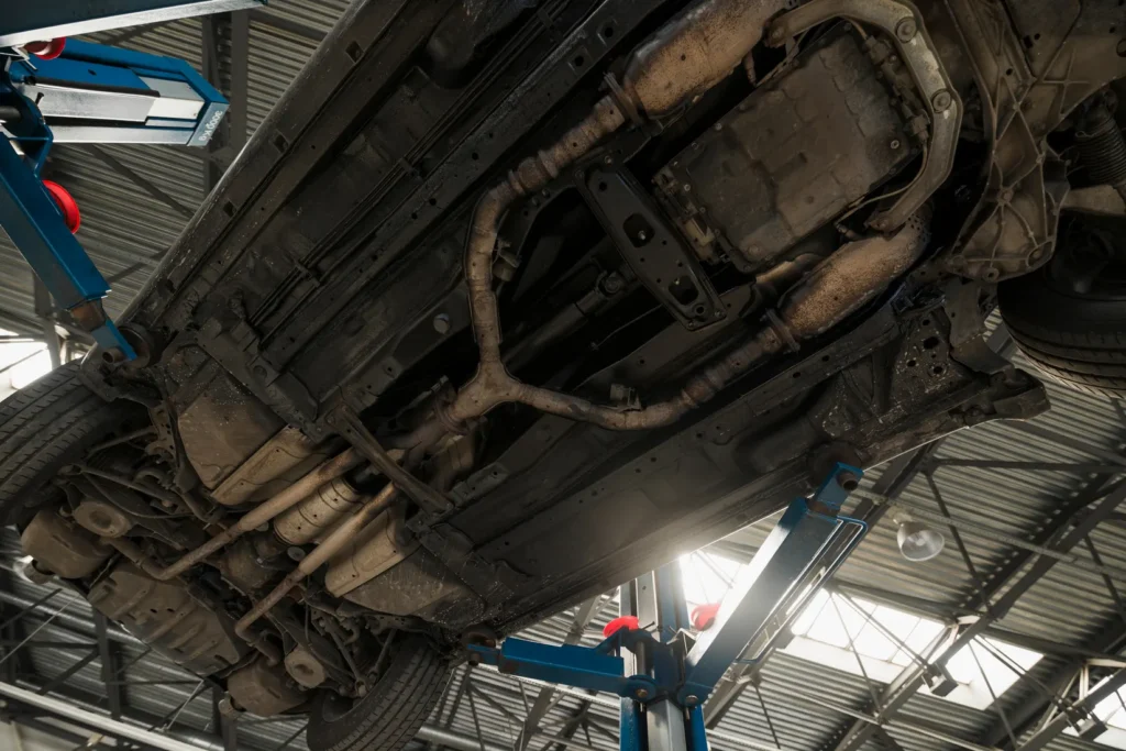 Underside of a car on a hoist showing the exhaust system